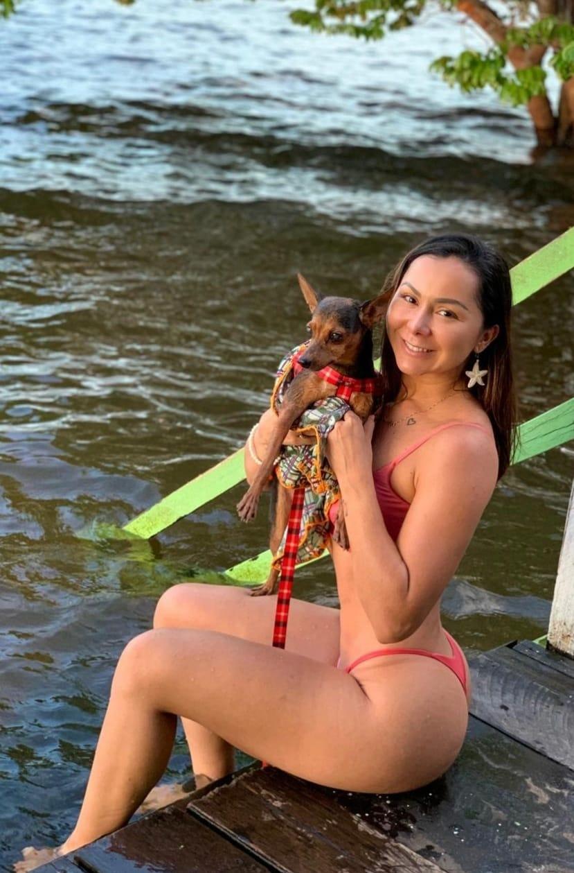 Leidy Knowles posa com seu pet na praia do Cajueiro, em Alter do Chão